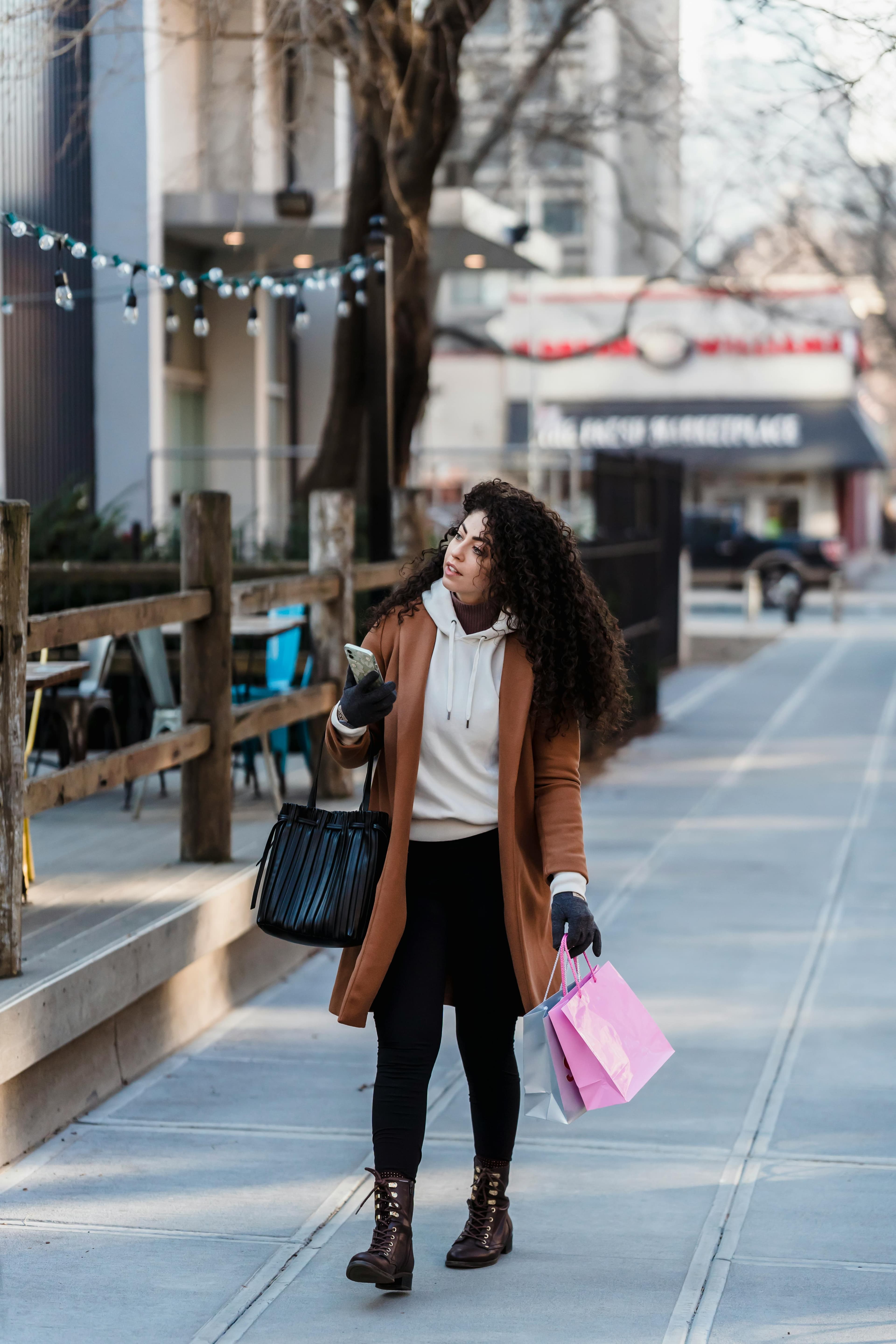 Woman searching on her phone while walking down a high street