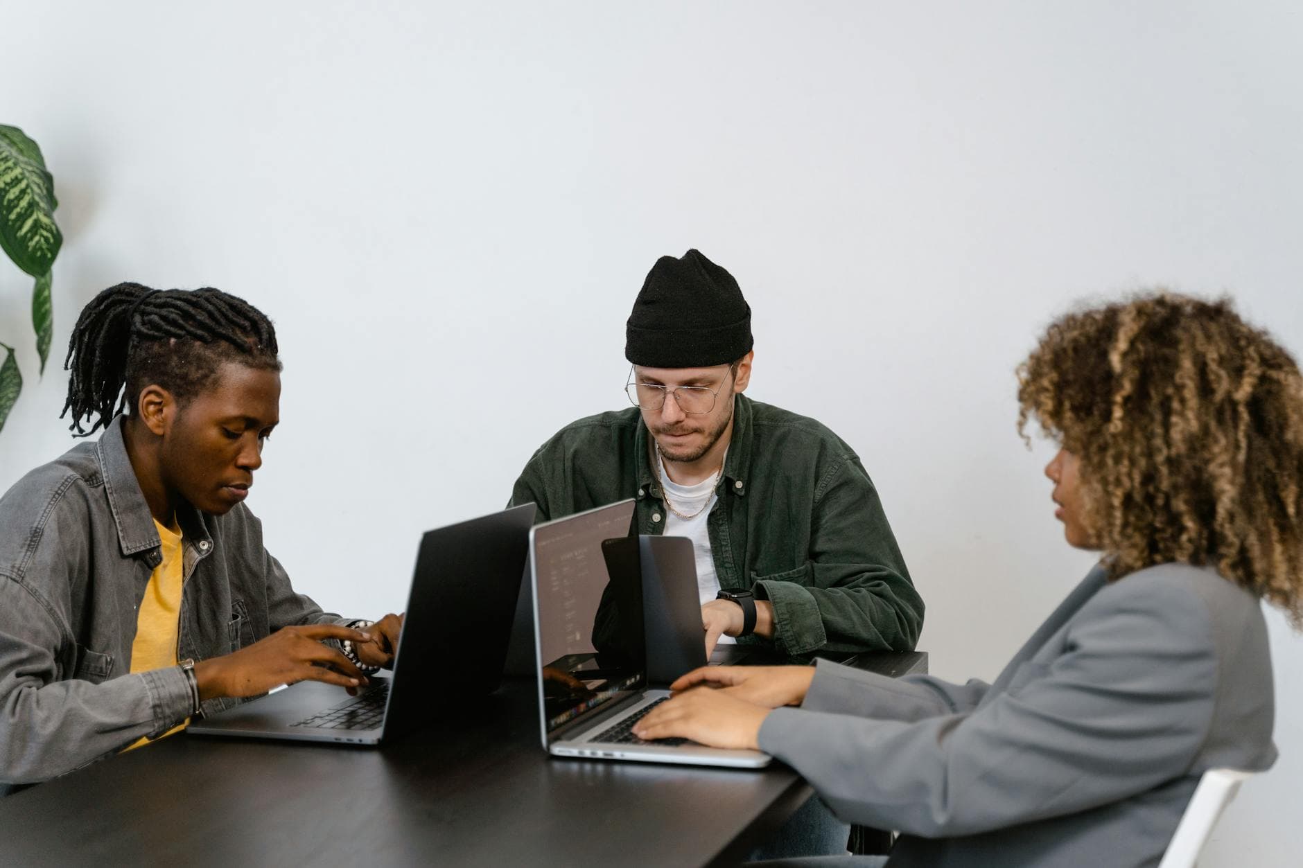 Diverse team of professionals collaborating on laptops in a modern office